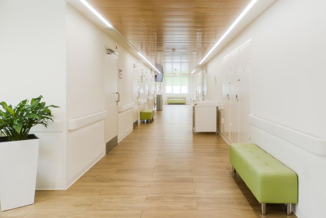 Daylit clinic corridor with timber ceiling and waiting benches