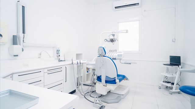 White dental operatory with integrated storage and a blue treatment chair