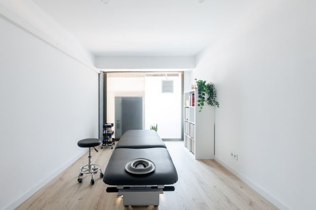 Minimal physiotherapy treatment room with daylight and storage