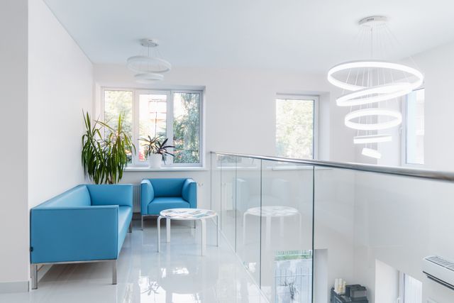 Clinic lounge with blue seating, glass balustrade and sculptural lighting