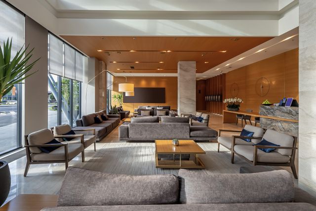 Contemporary hotel lounge with timber walls, marble reception and generous seating.