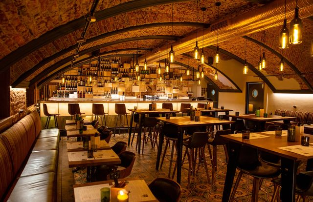 Restaurant and bar interior with a brick-vaulted ceiling and warm ambient lighting
