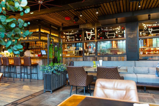 Cafe and bar with timber ceiling slats, industrial details and upholstered booth seating