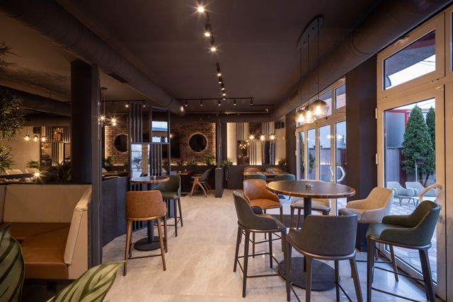 Modern restaurant with charcoal finishes, neutral dining furniture and curved chairs