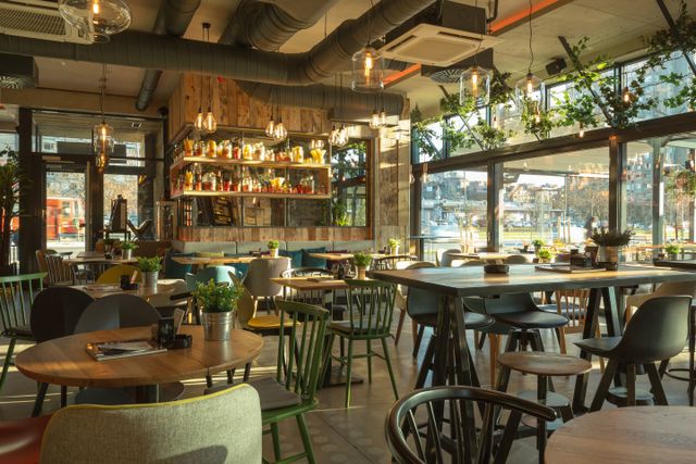 Urban restaurant with green chairs, timber finishes and generous natural daylight