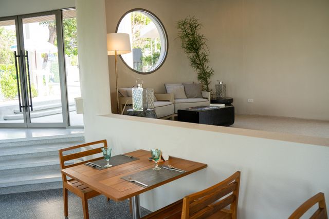 Minimalist cafe with timber dining furniture, split-level lounge and a circular window