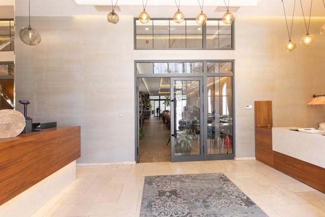 Hotel entrance with timber reception counters and suspended glass pendant lights