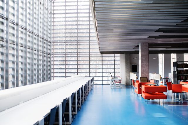 Daylit university library with study tables and lounge seating.