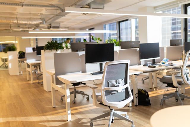 Light-filled office with shared workstations and task chairs.