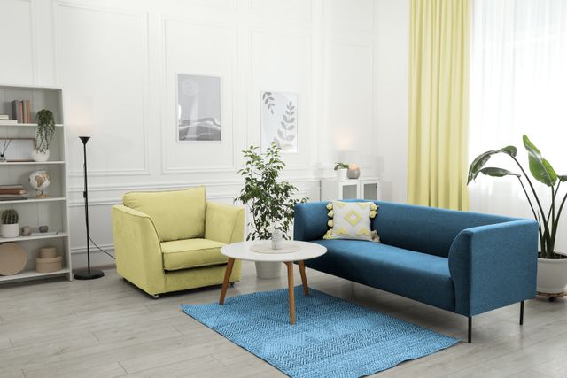 Blue sofa and yellow armchair arranged around a coffee table in a bright living room.