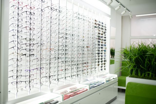 Optical store with illuminated eyewear display shelving and an upholstered seat