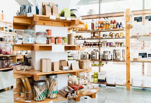 Bright specialty shop with timber display shelves holding refill jars, toiletries, brushes and packaged everyday goods.