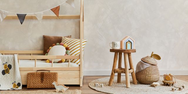 A timber bed and hanging decorations form a cozy children's room with Scandinavian-inspired styling.