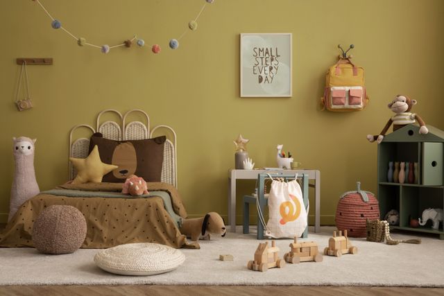 A woven bed, small desk and playful accessories create a warm, inviting children's room.